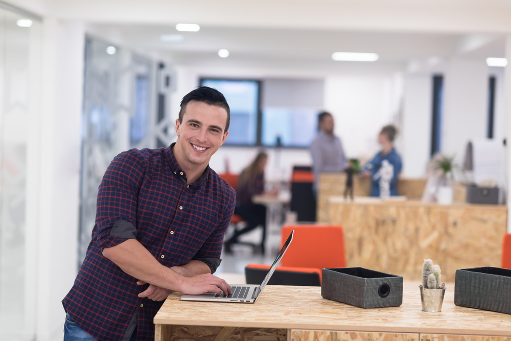 portrait of young businessman in casual clothes at modern  startup business office space,  working on laptop  computer